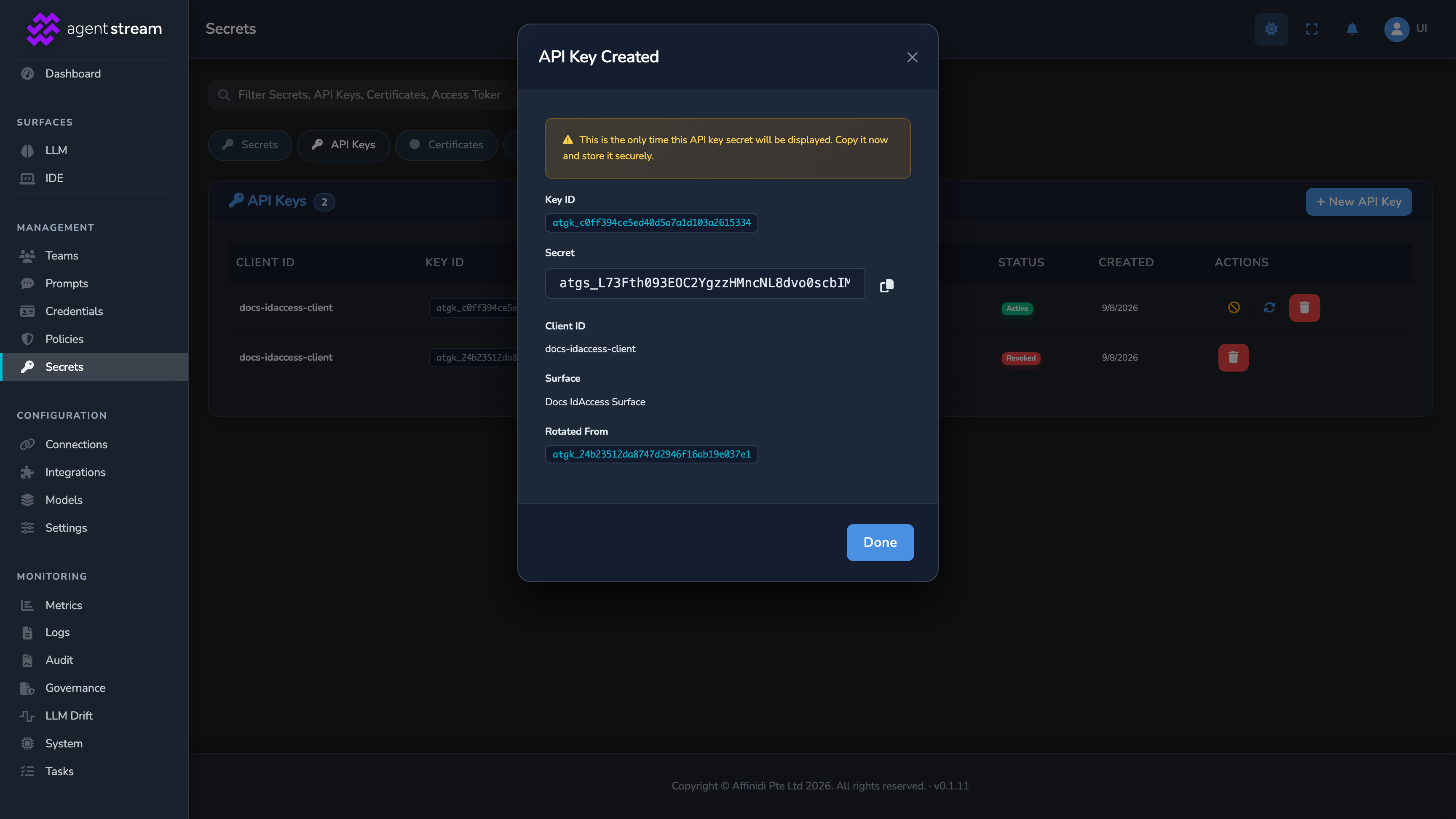 The API Key Created dialog after rotation, showing a new one-time secret and the Rotated From field naming the previous key, with the old key now Revoked in the list behind it